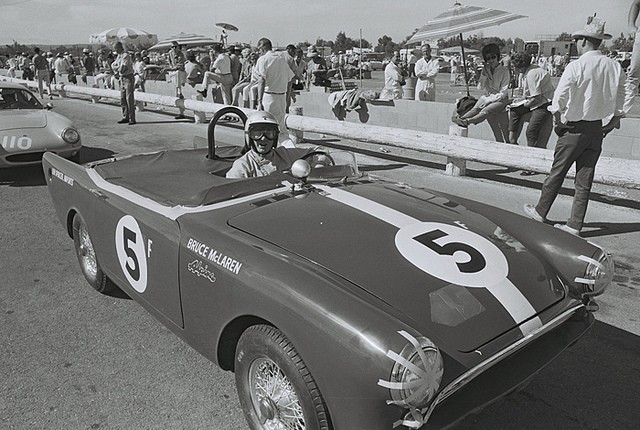 Bruce McLaren in Sunbeam Alpine at riverside